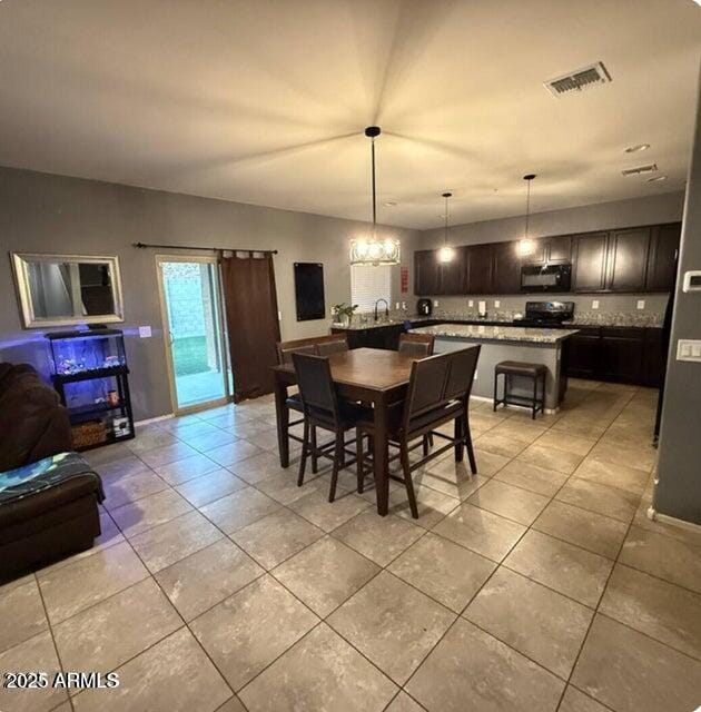 11644 W Redfield Rd, El Mirage, AZ 85335 - dining room featuring visible vents, light tile patterned floors, and a notable chandelier