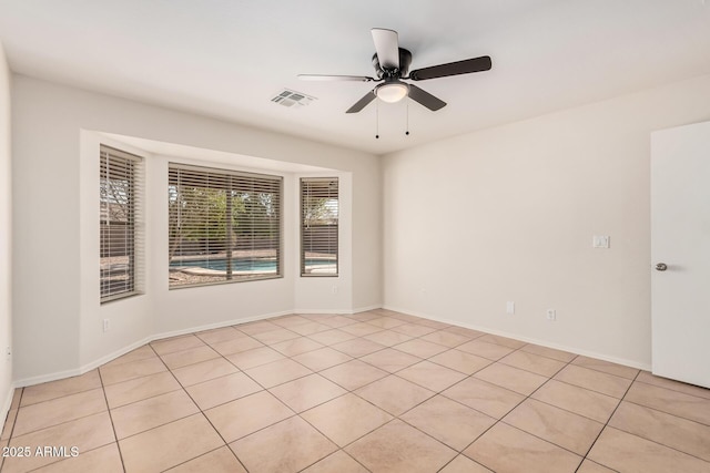 empty room with baseboards, visible vents, and a ceiling fan