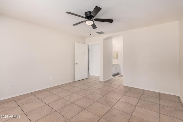 unfurnished room featuring a ceiling fan, arched walkways, visible vents, and baseboards