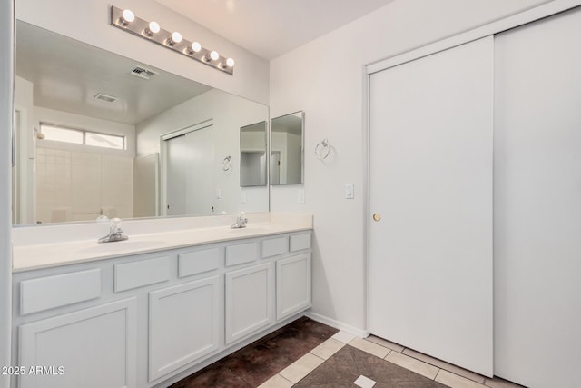 full bathroom with double vanity, tile patterned flooring, a sink, and visible vents