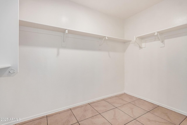 walk in closet with light tile patterned floors