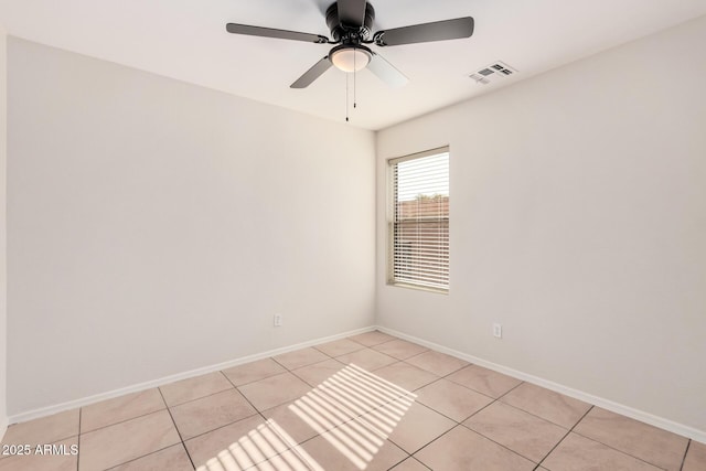 empty room with baseboards, visible vents, a ceiling fan, and light tile patterned flooring