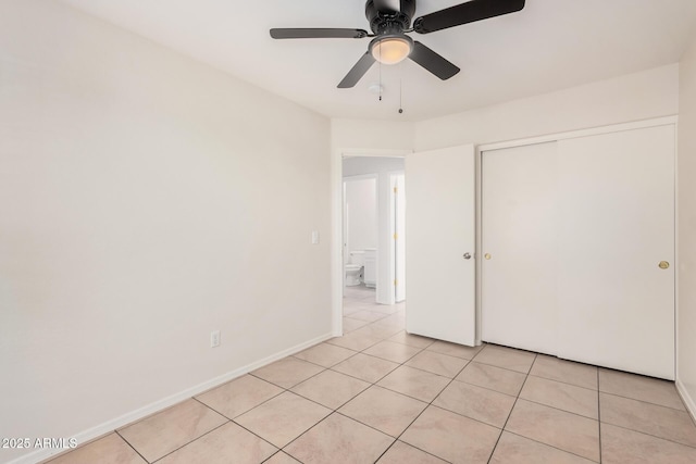 unfurnished bedroom featuring light tile patterned floors, ceiling fan, a closet, and baseboards