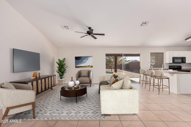 living room with vaulted ceiling, visible vents, ceiling fan, and light tile patterned flooring