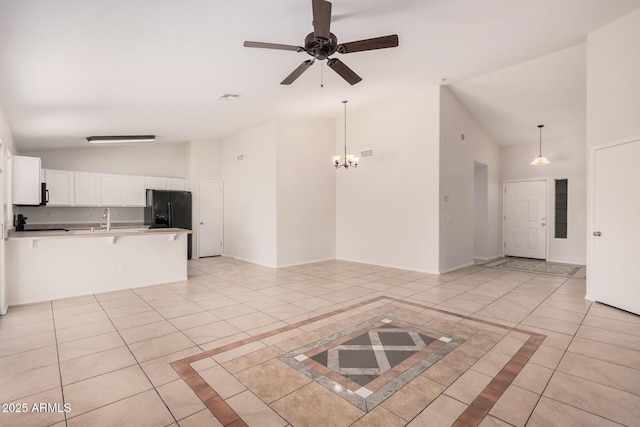 unfurnished living room with visible vents, light tile patterned flooring, a sink, baseboards, and ceiling fan with notable chandelier