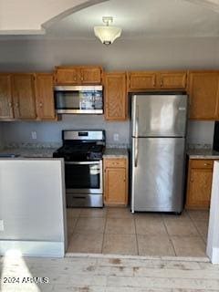 kitchen featuring stainless steel appliances and light tile patterned flooring