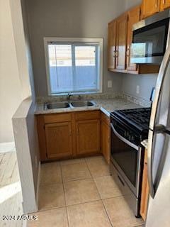 kitchen featuring sink, light tile patterned floors, and stainless steel appliances