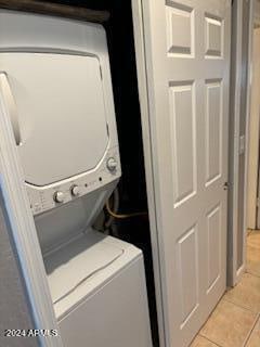 washroom featuring light tile patterned floors and stacked washer / dryer