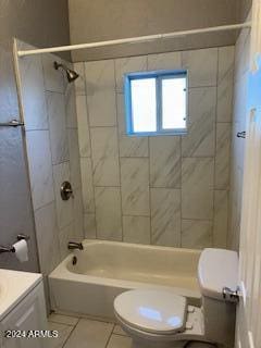 full bathroom featuring toilet, tiled shower / bath combo, vanity, and tile patterned flooring