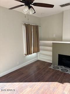 unfurnished living room with ceiling fan and dark hardwood / wood-style floors