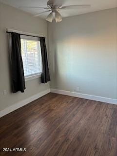 spare room with dark wood-type flooring and ceiling fan