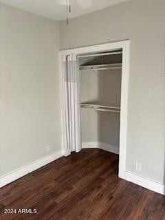 unfurnished bedroom featuring a closet and dark hardwood / wood-style flooring