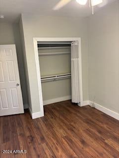 unfurnished bedroom featuring ceiling fan, dark hardwood / wood-style floors, and a closet