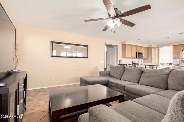 living room featuring light tile patterned floors, baseboards, ceiling fan, and visible vents