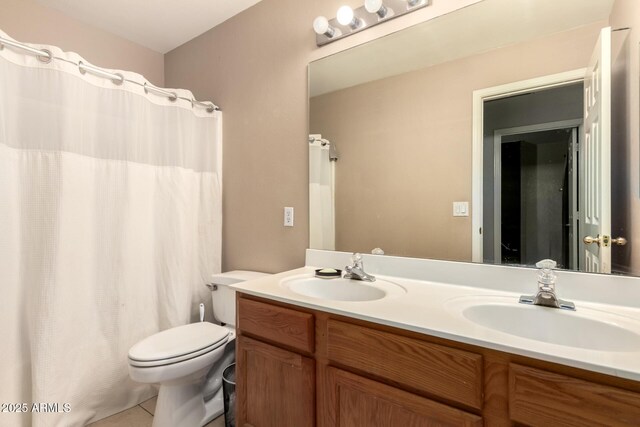 full bath featuring a sink, tile patterned flooring, toilet, and double vanity
