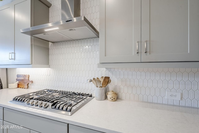 10509 W Harmony Ln, Peoria, AZ 85382 - kitchen featuring wall chimney exhaust hood, stainless steel gas stovetop, light countertops, decorative backsplash, and gray cabinetry
