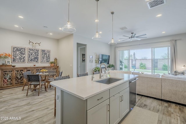 10509 W Harmony Ln, Peoria, AZ 85382 - kitchen with a sink, open floor plan, light wood-type flooring, dishwasher, and light countertops