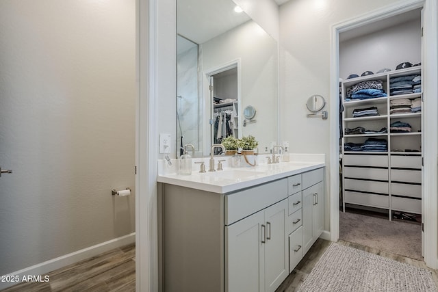 10509 W Harmony Ln, Peoria, AZ 85382 - full bathroom with a spacious closet, double vanity, wood finished floors, and baseboards
