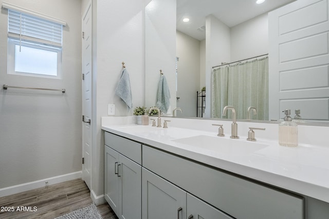 10509 W Harmony Ln, Peoria, AZ 85382 - bathroom with wood finished floors, double vanity, baseboards, and recessed lighting