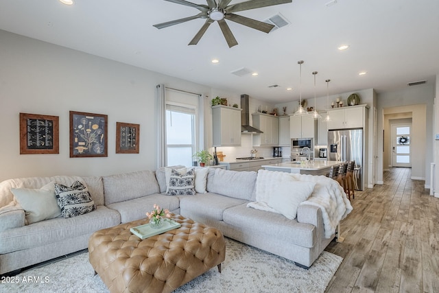 10509 W Harmony Ln, Peoria, AZ 85382 - living room featuring healthy amount of natural light, a ceiling fan, recessed lighting, light wood-type flooring, and baseboards