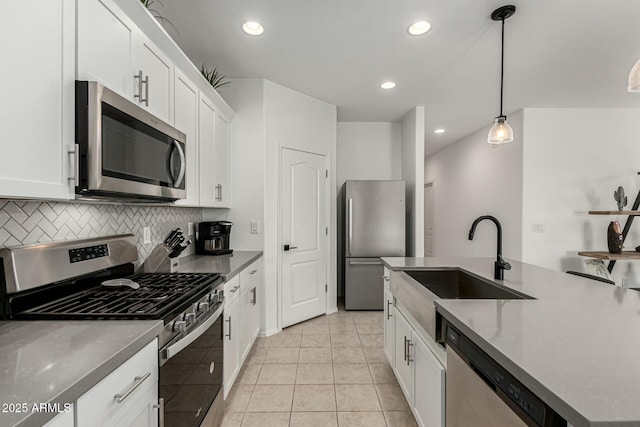 kitchen with decorative light fixtures, white cabinetry, stainless steel appliances, sink, and light tile patterned flooring