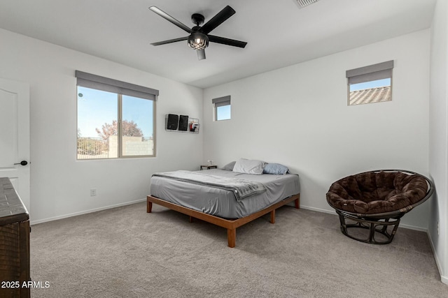 bedroom featuring ceiling fan, light carpet, and multiple windows