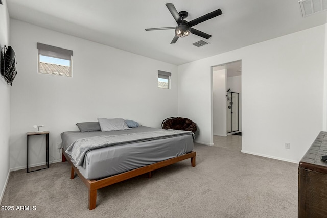 bedroom featuring ceiling fan, light colored carpet, and multiple windows