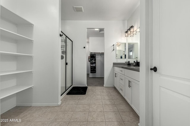 bathroom with tile patterned floors, walk in shower, and vanity