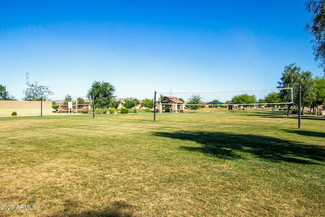 view of home's community featuring volleyball court and a lawn