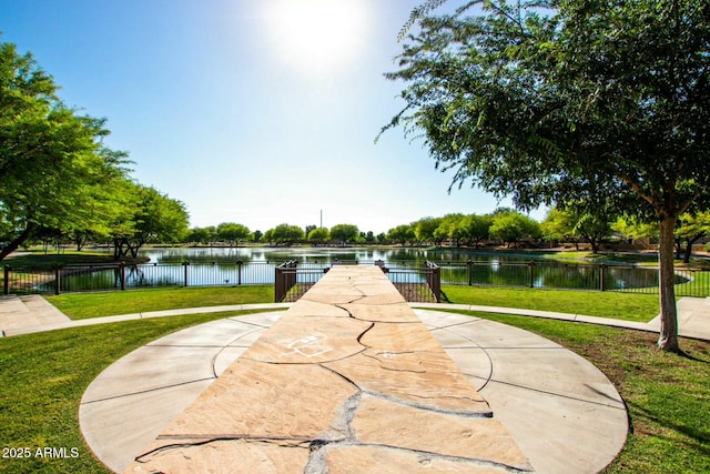 surrounding community featuring a lawn and a water view