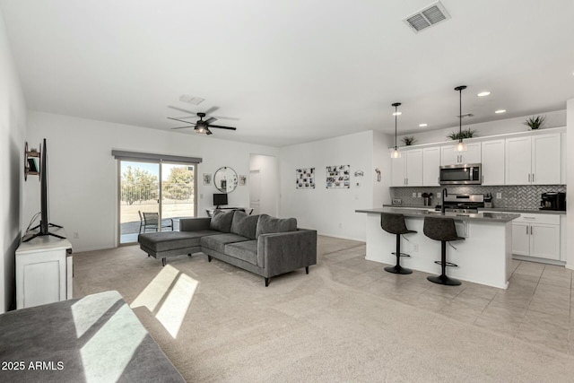 carpeted living room featuring ceiling fan