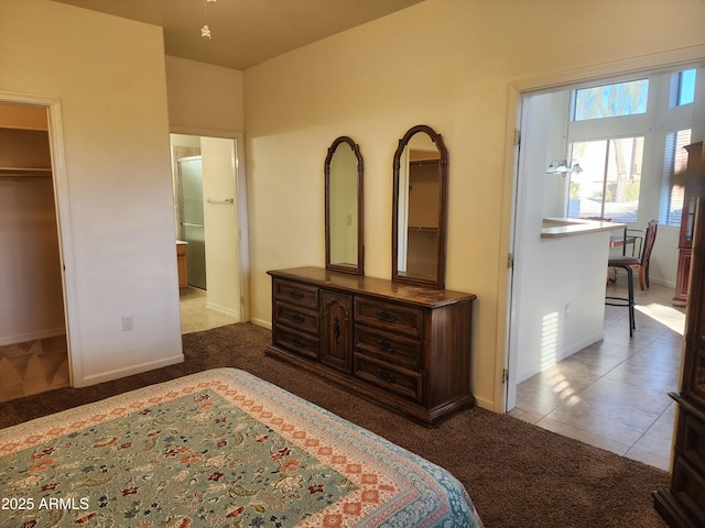 bedroom with ensuite bath, tile patterned flooring, carpet flooring, and baseboards