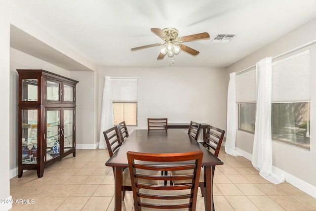 dining room with light tile patterned floors, a ceiling fan, and baseboards