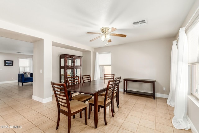 dining area featuring plenty of natural light, light tile patterned flooring, visible vents, and ceiling fan