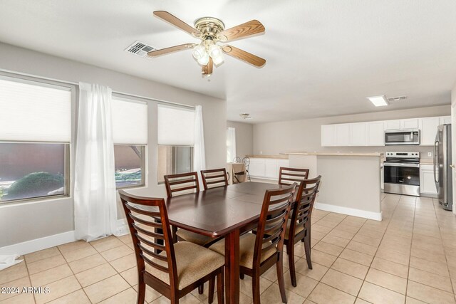 dining space featuring light tile patterned flooring and ceiling fan