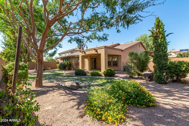 view of front of home with stucco siding and fence