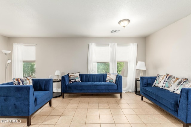 living room with plenty of natural light, visible vents, and light tile patterned floors