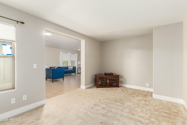 unfurnished room featuring carpet flooring, baseboards, and plenty of natural light