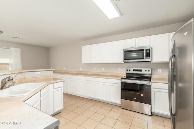 kitchen featuring visible vents, a sink, stainless steel appliances, light countertops, and light tile patterned floors