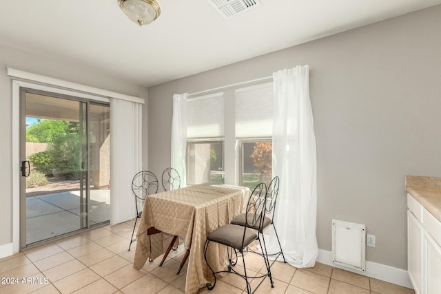 dining room featuring light tile patterned floors, baseboards, and visible vents