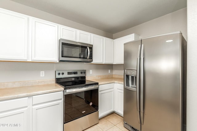 kitchen with white cabinets, light tile patterned floors, and stainless steel appliances