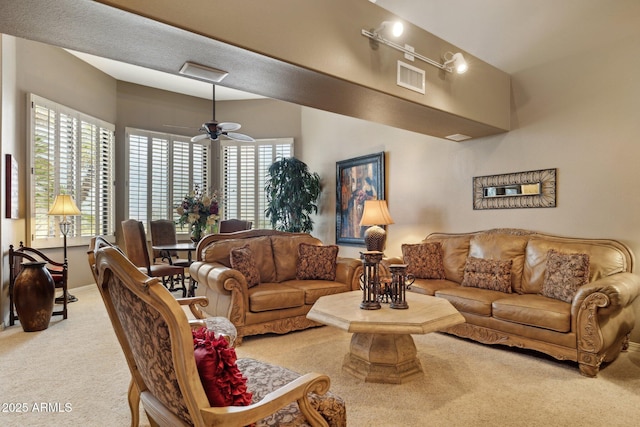 living area with visible vents, carpet floors, and a ceiling fan