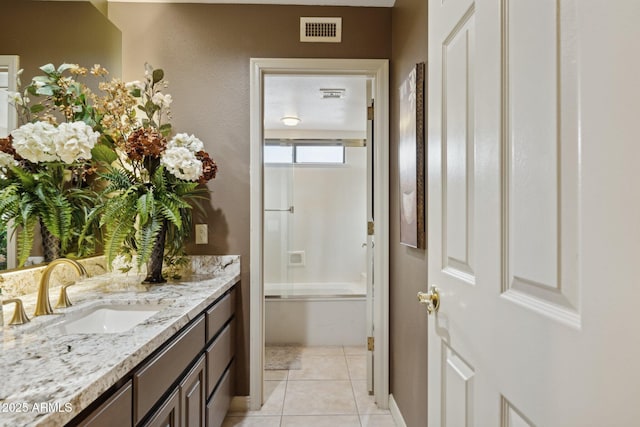 bathroom with vanity, washtub / shower combination, visible vents, and tile patterned flooring