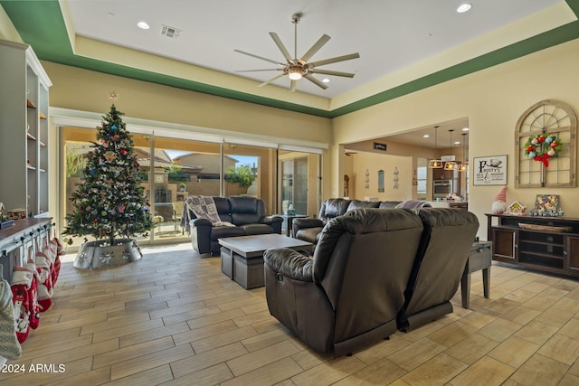 living room with a tray ceiling and ceiling fan