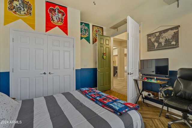 bedroom featuring parquet floors and a closet