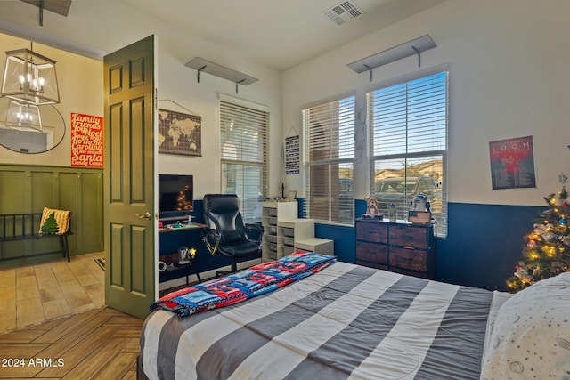 bedroom with light parquet floors and a chandelier