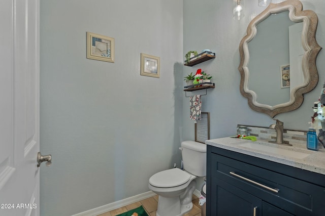 bathroom with tile patterned flooring, vanity, and toilet