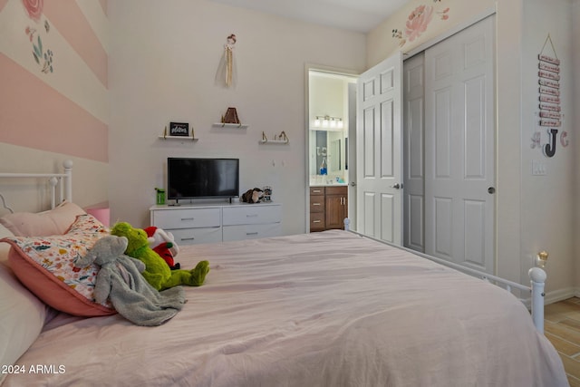 bedroom with hardwood / wood-style flooring, ensuite bath, and a closet