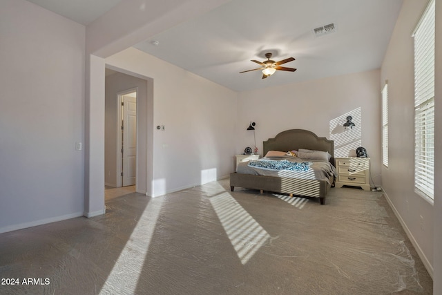 carpeted bedroom with multiple windows and ceiling fan