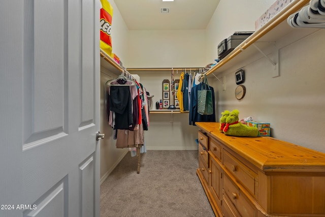 walk in closet featuring light colored carpet